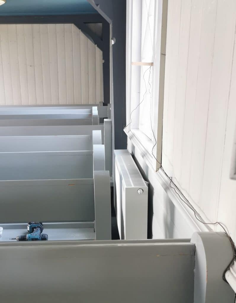 Kirkonpenkkien lyhennys lämpöpattereiden asentamista varten